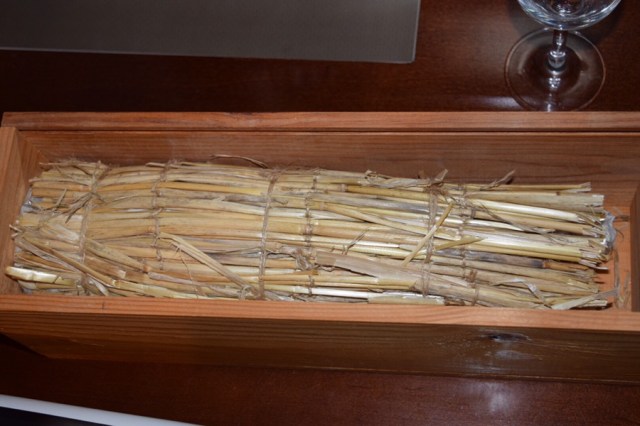 The bottle was wrapped and tied with strands of hay.